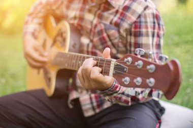 Genç hipster adam onun tatile rahatlatıcı için gitar çalmak zevk ile doğal ve taze hava.