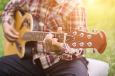 Genç hipster adam onun tatile rahatlatıcı için gitar çalmak zevk ile doğal ve taze hava.