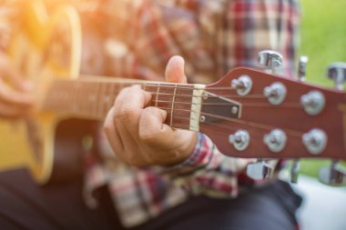 Genç hipster adam onun tatile rahatlatıcı için gitar çalmak zevk ile doğal ve taze hava.