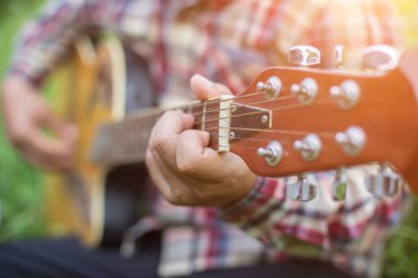 Genç hipster adam onun tatile rahatlatıcı için gitar çalmak zevk ile doğal ve taze hava.