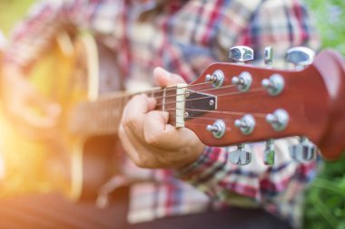 Genç hipster adam onun tatile rahatlatıcı için gitar çalmak zevk ile doğal ve taze hava.