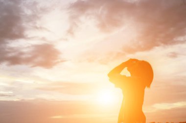 Güzel bir arka plan için dua eden bir kadın silueti.