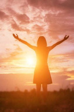 Güzel bir arka plan için dua eden bir kadın silueti.