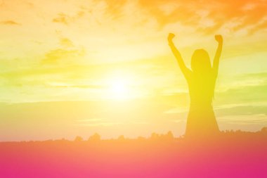 Güzel bir arka plan için dua eden bir kadın silueti.