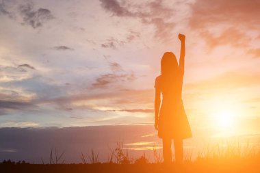 Güzel bir arka plan için dua eden bir kadın silueti.