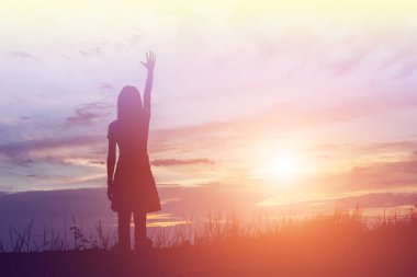 Güzel bir arka plan için dua eden bir kadın silueti.