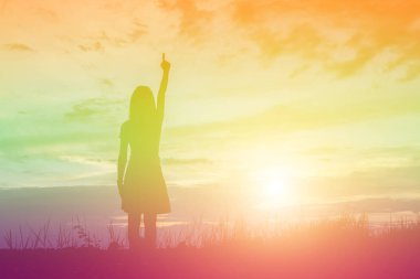 Güzel bir arka plan için dua eden bir kadın silueti.