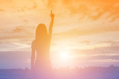 Güzel bir arka plan için dua eden bir kadın silueti.