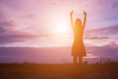 Güzel bir arka plan için dua eden bir kadın silueti.