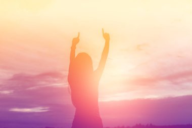 Güzel bir arka plan için dua eden bir kadın silueti.