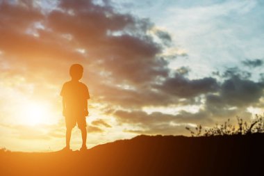 mutlu bir çocuk silüeti ve mutlu zaman günbatımı