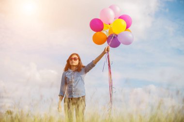 Güzel kız sahilde balonlarla atlama