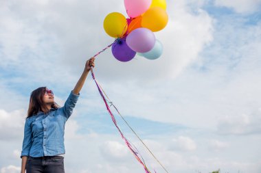 Güzel kız sahilde balonlarla atlama