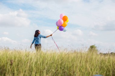 Güzel kız sahilde balonlarla atlama