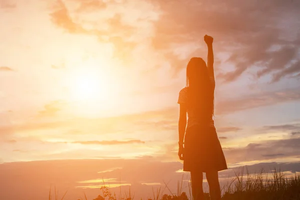 Silhouette of woman praying over beautiful sky background