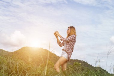 Açık peyzaj, yaşam tarzı dağ doğa arka plan üzerinde genç hippi kadını retro kamera çekimi ile vurdu.