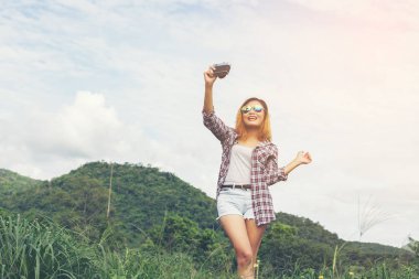 Açık peyzaj, yaşam tarzı dağ doğa arka plan üzerinde genç hippi kadını retro kamera çekimi ile vurdu.