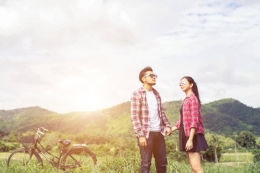 Genç hippi çift elele yürümek çayır rahatlatıcı ve doğal atmosfer çok doğaldır.