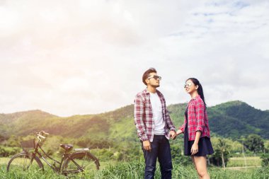 Genç hippi çift elele yürümek çayır rahatlatıcı ve doğal atmosfer çok doğaldır.