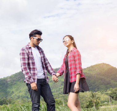 Genç hippi çift elele yürümek çayır rahatlatıcı ve doğal atmosfer çok doğaldır.