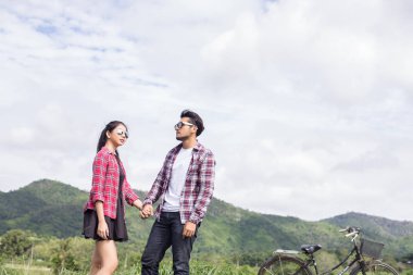 Genç hippi çift elele yürümek çayır rahatlatıcı ve doğal atmosfer çok doğaldır.