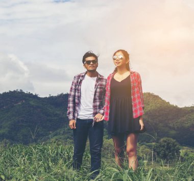 Genç hippi çift elele yürümek çayır rahatlatıcı ve doğal atmosfer çok doğaldır.