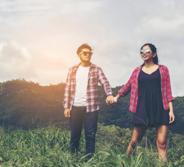 Genç hippi çift elele yürümek çayır rahatlatıcı ve doğal atmosfer çok doğaldır.