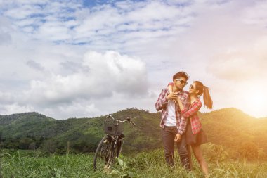 Genç hippi çift elele yürümek çayır rahatlatıcı ve doğal atmosfer çok doğaldır.