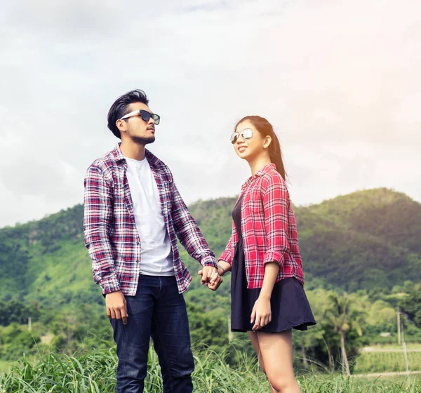 Genç hippi çift elele yürümek çayır rahatlatıcı ve doğal atmosfer çok doğaldır.