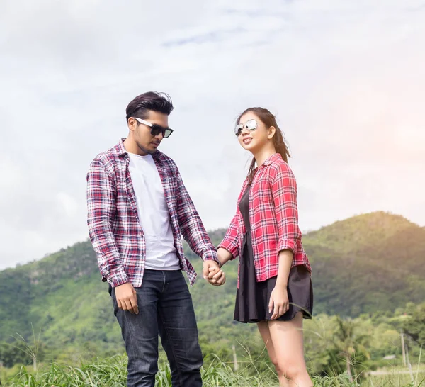 Genç hippi çift elele yürümek çayır rahatlatıcı ve doğal atmosfer çok doğaldır.