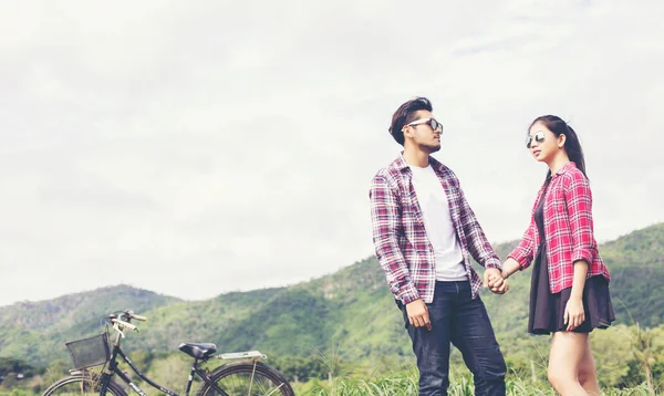 Genç hippi çift elele yürümek çayır rahatlatıcı ve doğal atmosfer çok doğaldır.