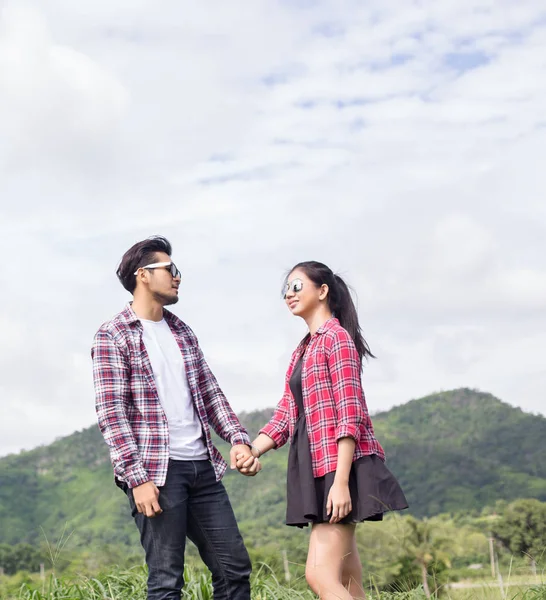 Genç hippi çift elele yürümek çayır rahatlatıcı ve doğal atmosfer çok doğaldır.