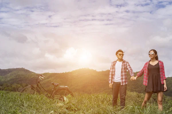 Genç hippi çift elele yürümek çayır rahatlatıcı ve doğal atmosfer çok doğaldır.