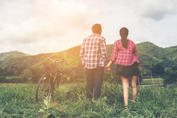 Genç hippi çift elele yürümek çayır rahatlatıcı ve doğal atmosfer çok doğaldır.