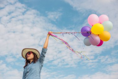 Güzel kız sahilde balonlarla atlama