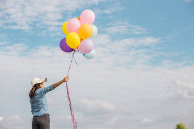 Güzel kız sahilde balonlarla atlama