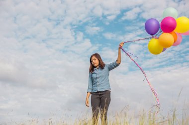 Güzel kız sahilde balonlarla atlama