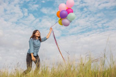 Güzel kız sahilde balonlarla atlama