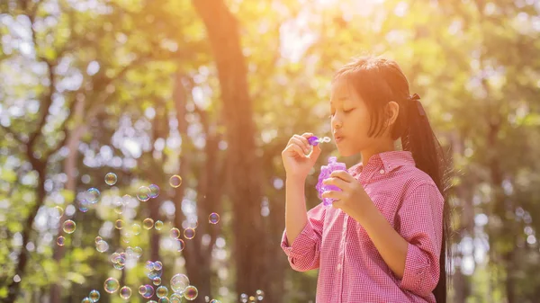 公園で泡を吹くピンクのシャツを着てかわいい女の子 ヴィンテージスタイル — ストック写真