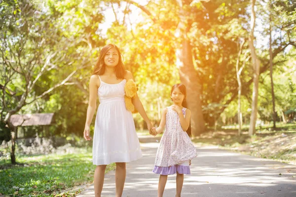 Sevimli küçük kız renkli balonlar tutan, mavi gökyüzü ve bulutlara karşı çayırçalışan.