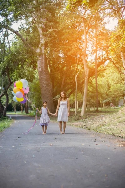 可爱的小女孩拿着五颜六色的气球 在草地上奔跑着蓝天白云 — 图库照片