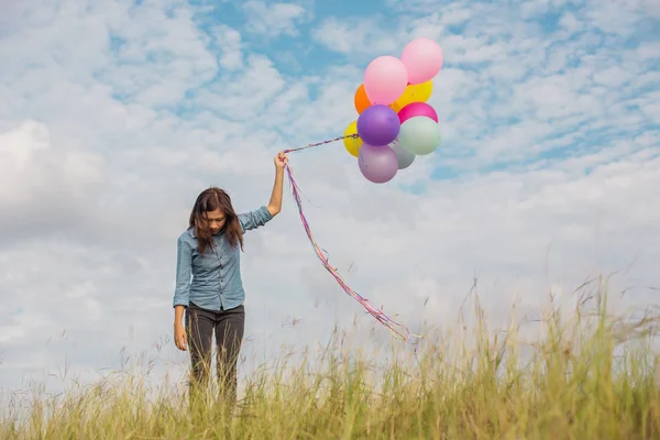 Beautiful Girl jumping with balloons on the beach