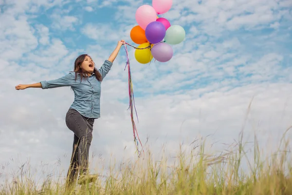 Güzel kız sahilde balonlarla atlama