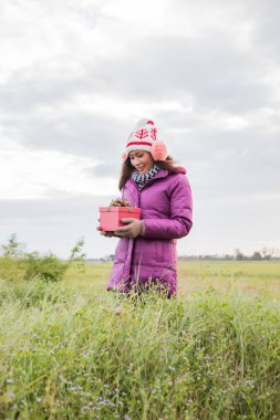 Elinde hediye ile mutlu genç kadın. Noel ve kış konsepti.
