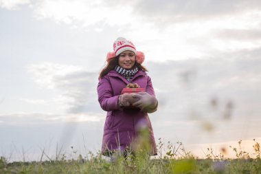 Elinde hediye ile mutlu genç kadın. Noel ve kış konsepti.