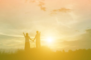 bir adam ve birlikte yürüyen birbirleri ile elele kadın silüeti.