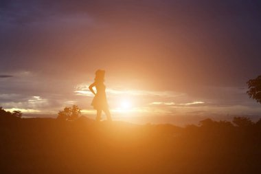 Güzel bir arka plan için dua eden bir kadın silueti.