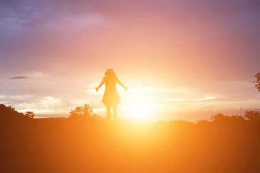 Güzel bir arka plan için dua eden bir kadın silueti.