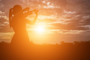 Genç kadın arka planda dağlar ile keman çalıyor