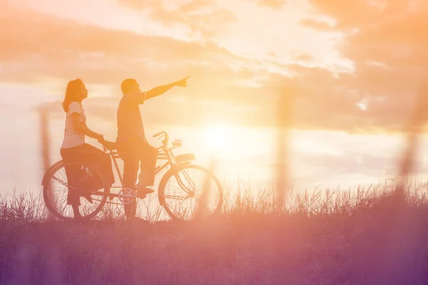 自転車の愛幸せな時間で甘いの若いカップルのシルエット — ストック写真